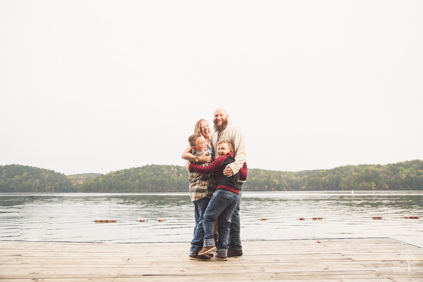 Laughing family of four crushed together on Lake Arrowhead dock