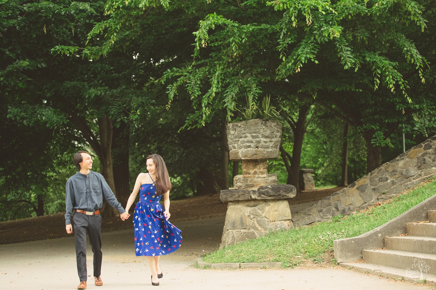 Cute engaged couple holding hands and having fun walking while she swishes her dress