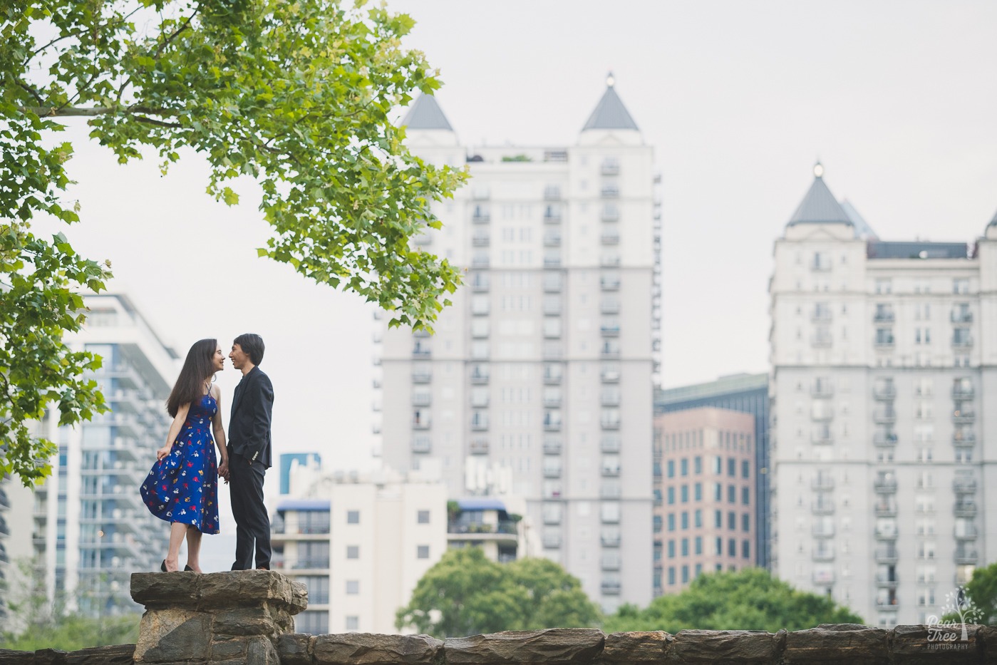 Sweet couple about to kiss in Atlanta skyline during  their engagement photography session