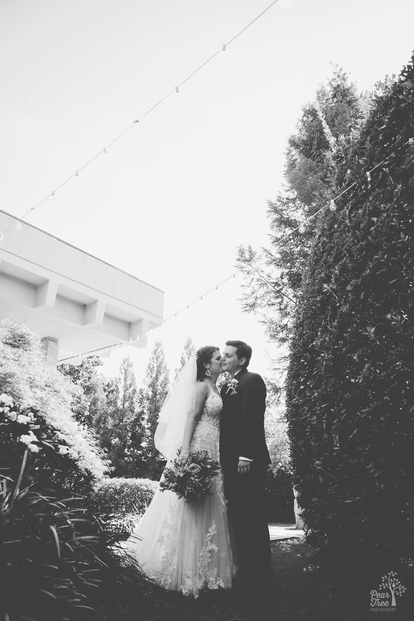 Black and white photograph of Atlanta wedding couple standing close in the garden outside The Atrium