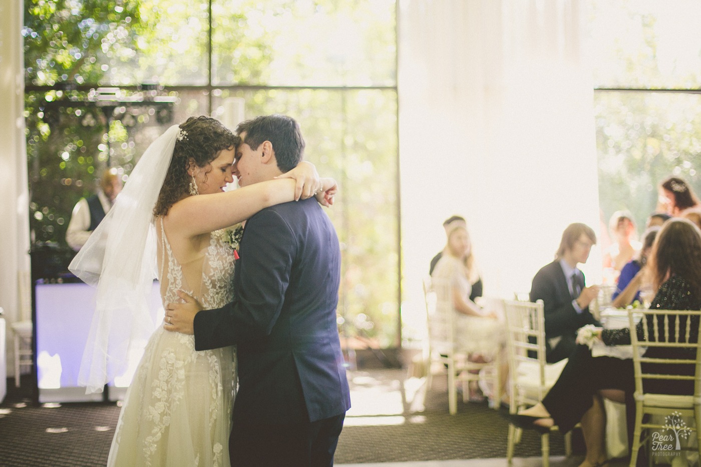 Bride and groom holding each other during their first dance on The Atrium dance floor outside of Atlanta