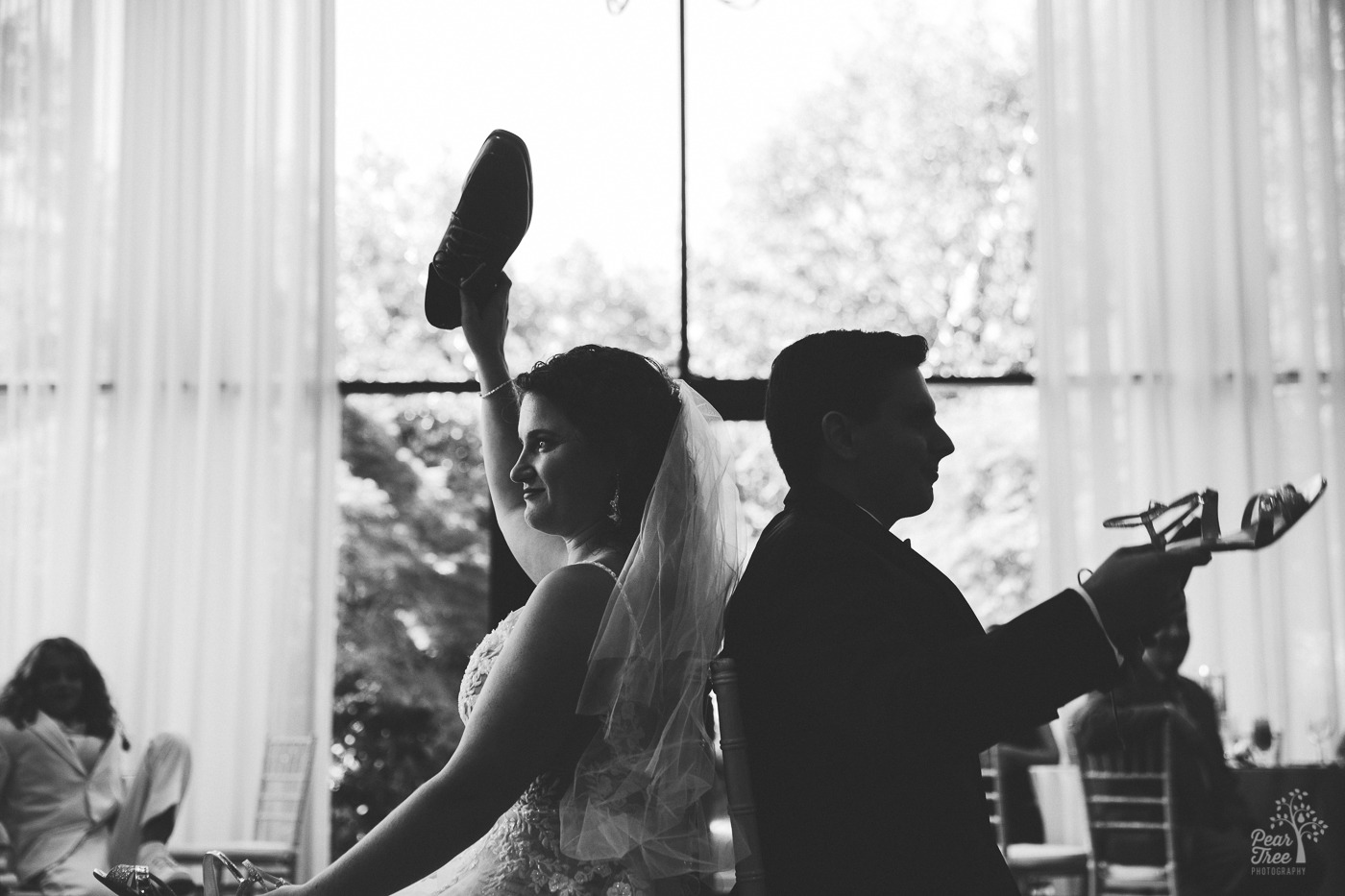 Black and white photograph of Atlanta wedding couple playing the shoe game at The Atrium