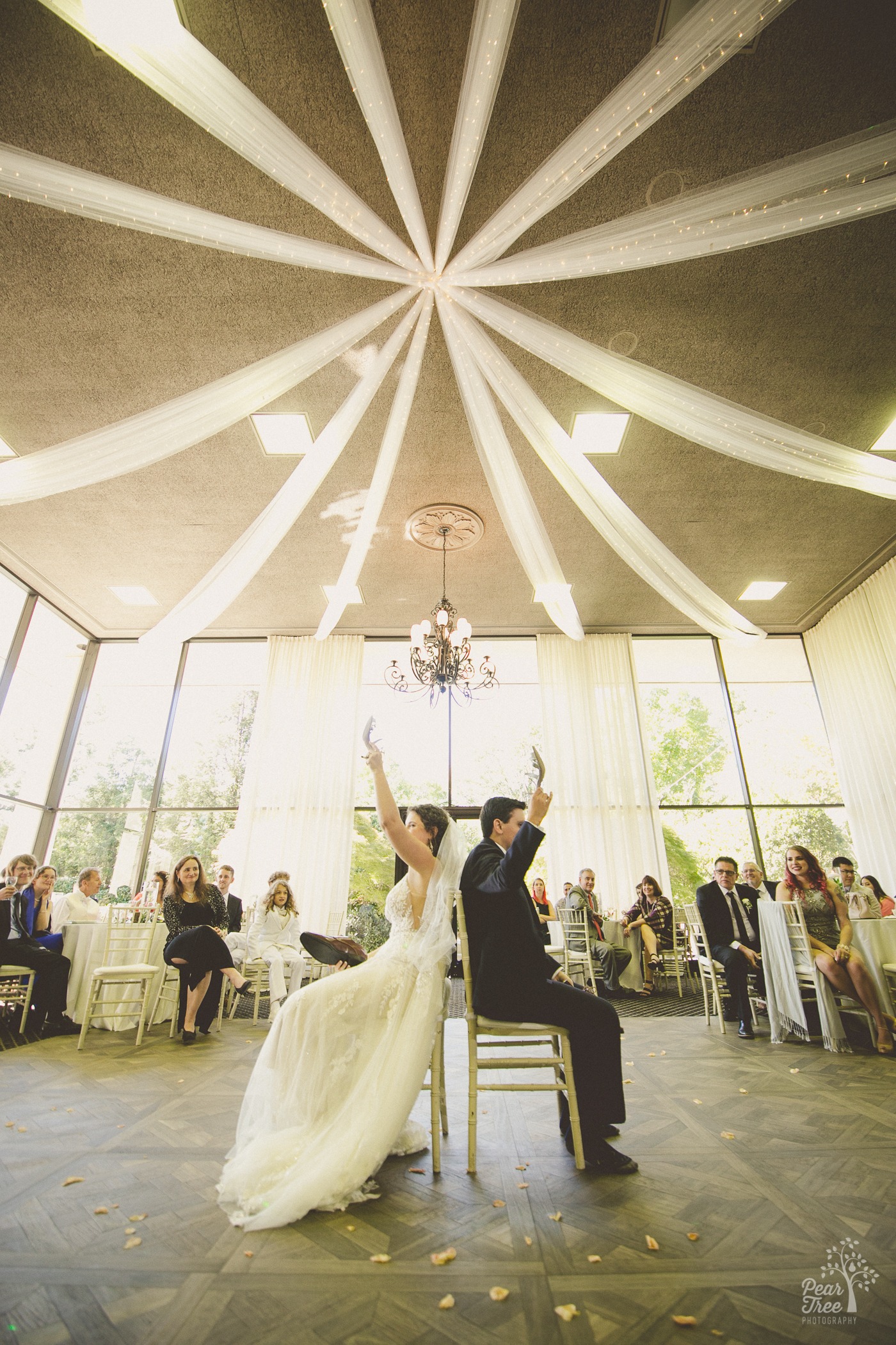 Bride and groom holding up the bride's shoe during their Atlanta wedding at The ATrium