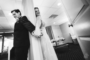 Bride and groom holding hands around a doorway inside The Atrium on their Atlanta wedding day