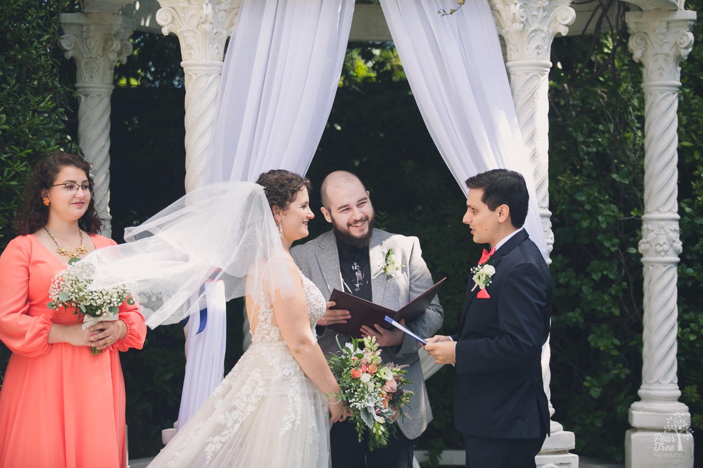 Bride's veil blows in the wind during her Atlanta wedding ceremony at The Atrium