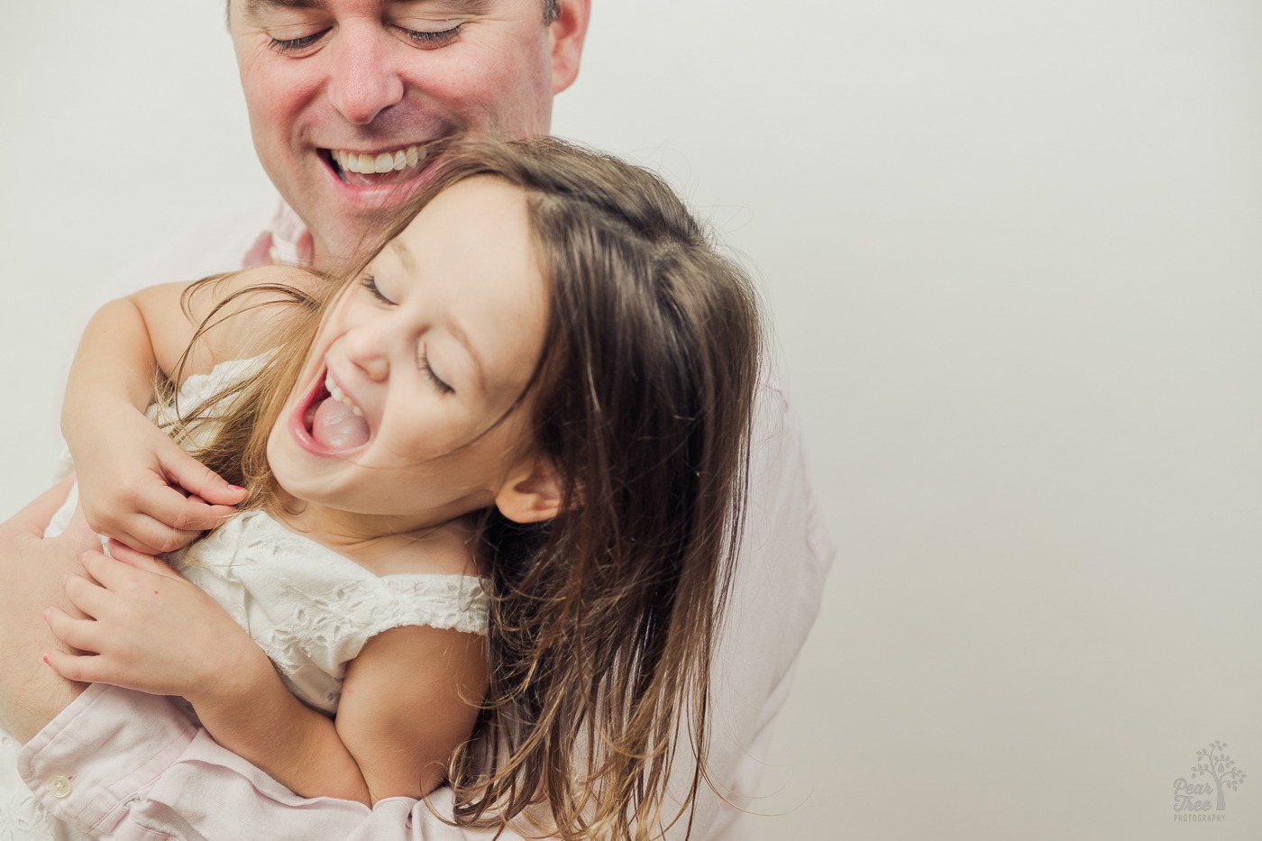 Father and daughter laughing as he tickles her