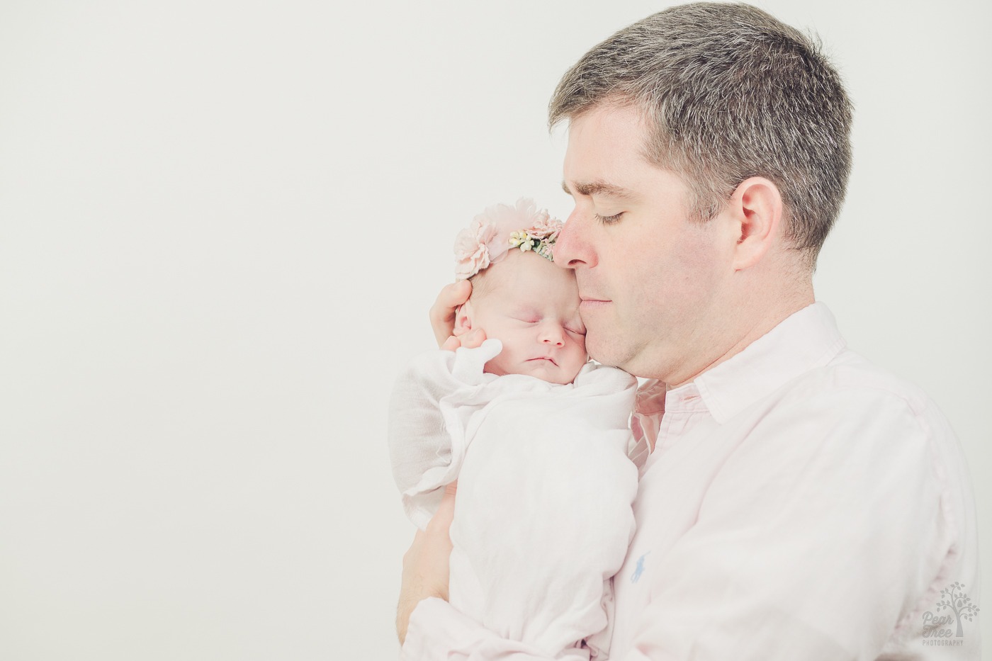 Dad holding his baby close to his face for newborn photographs in his Atlanta home