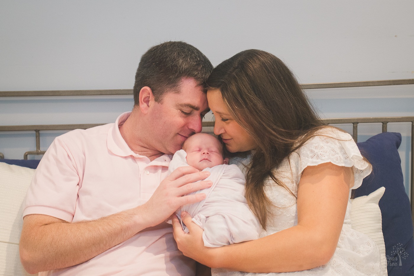 Sweet parents holding and nuzzling their newborn baby daughter