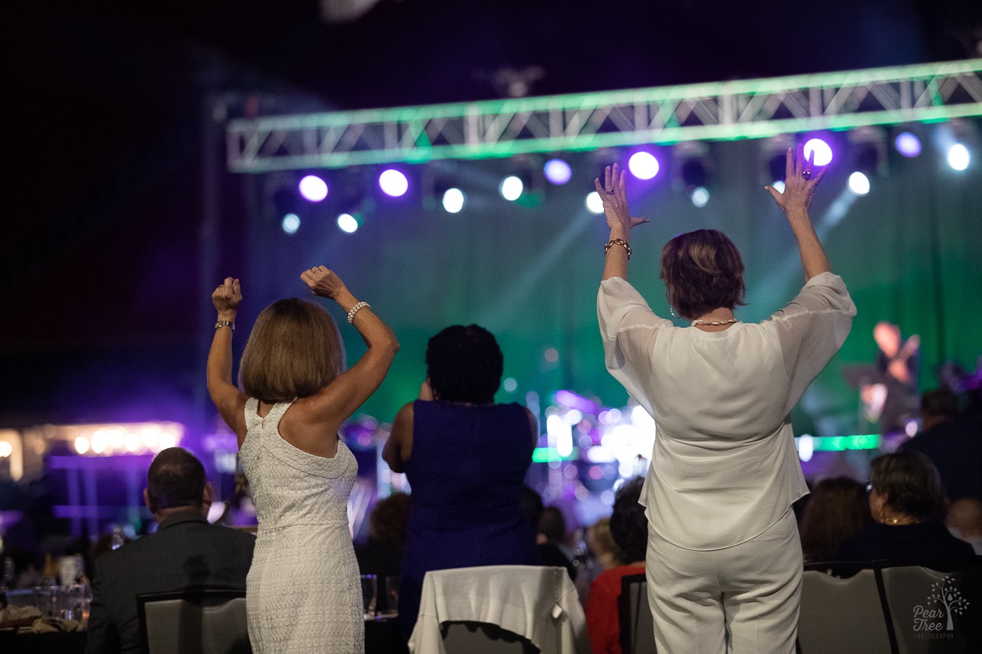 Covenant House Georgia supporters dancing with arms stretched over their heads. During Night of Broadway Stars performance at Atlanta Mercedes Benz stadium