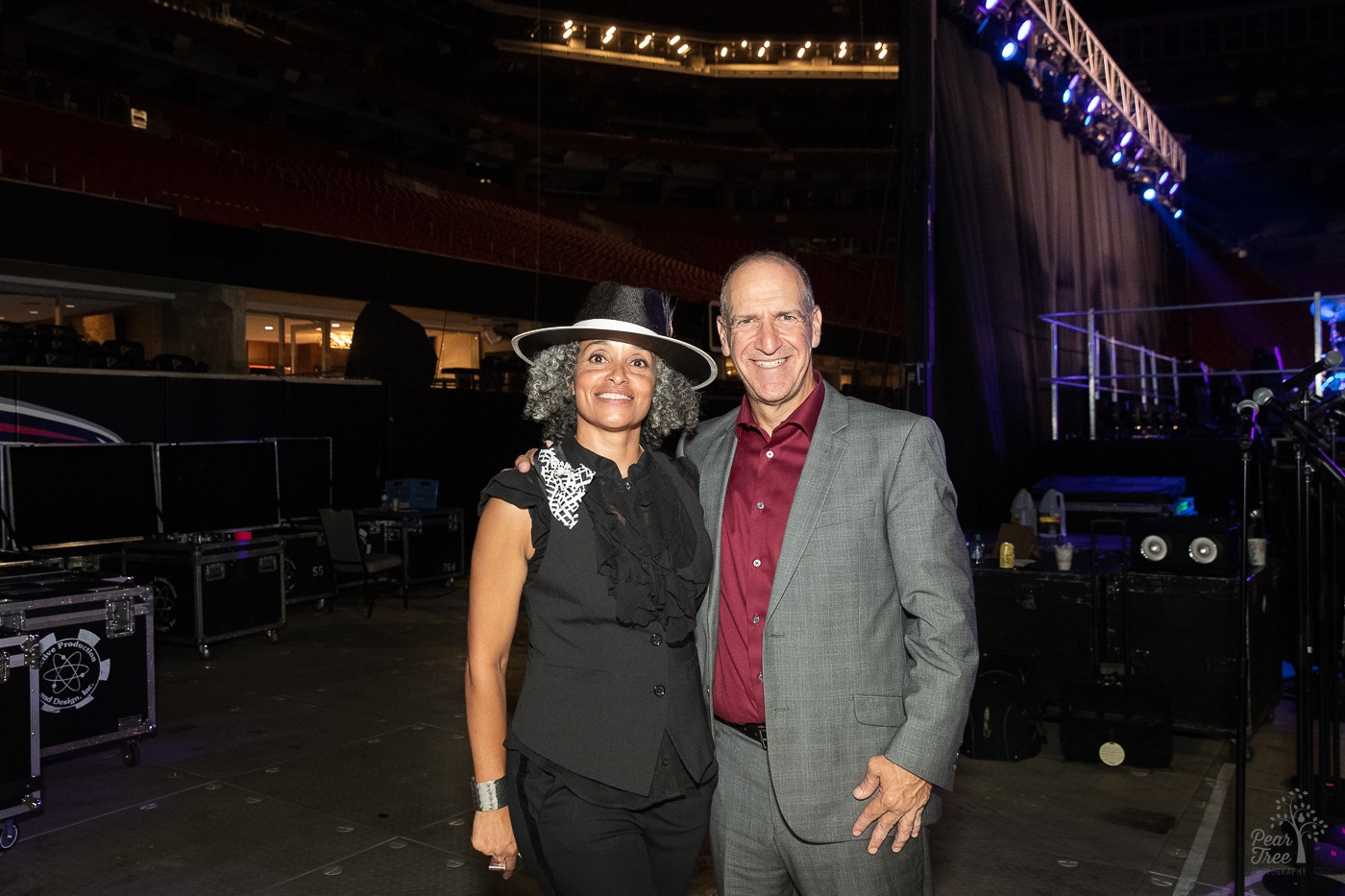 Dr. Alie Redd standing close and smiling with Neil Berg. Inside Mercedes Benz stage after Night of Broadway Stars 2021 event for Covenant House Georgia.