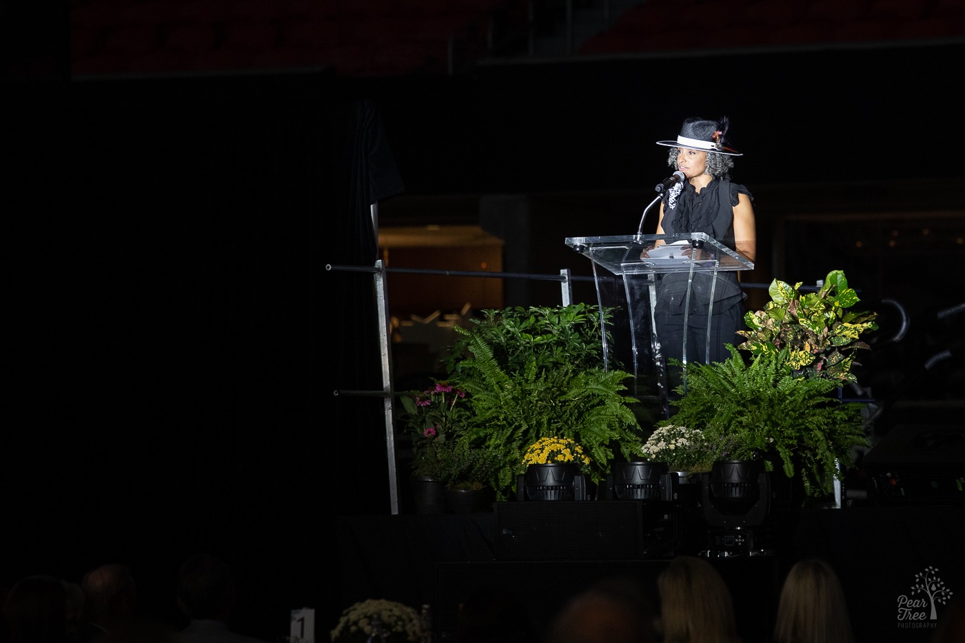 Dr. Aliezoria Redd of Covenant House Georgia speaking at a glass podium before Night of Broadway Stars event