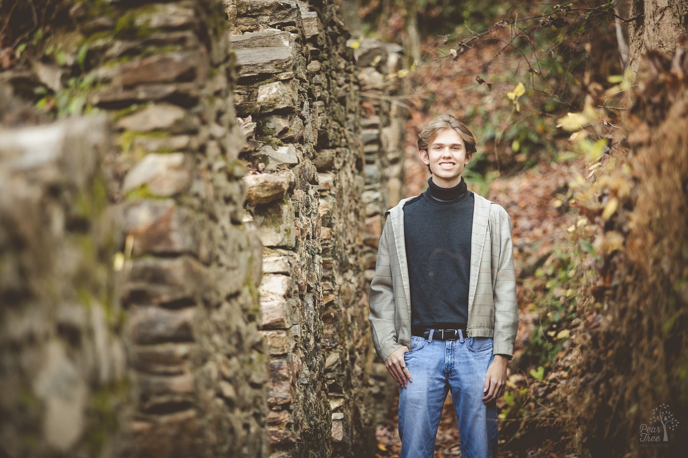 Cute boy standing with thumb in jeans pocket next to East Cobb's paper mill ruins at Sope Creek