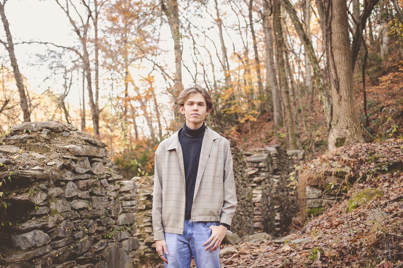 Serious boy standing in middle of old paper mill ruins