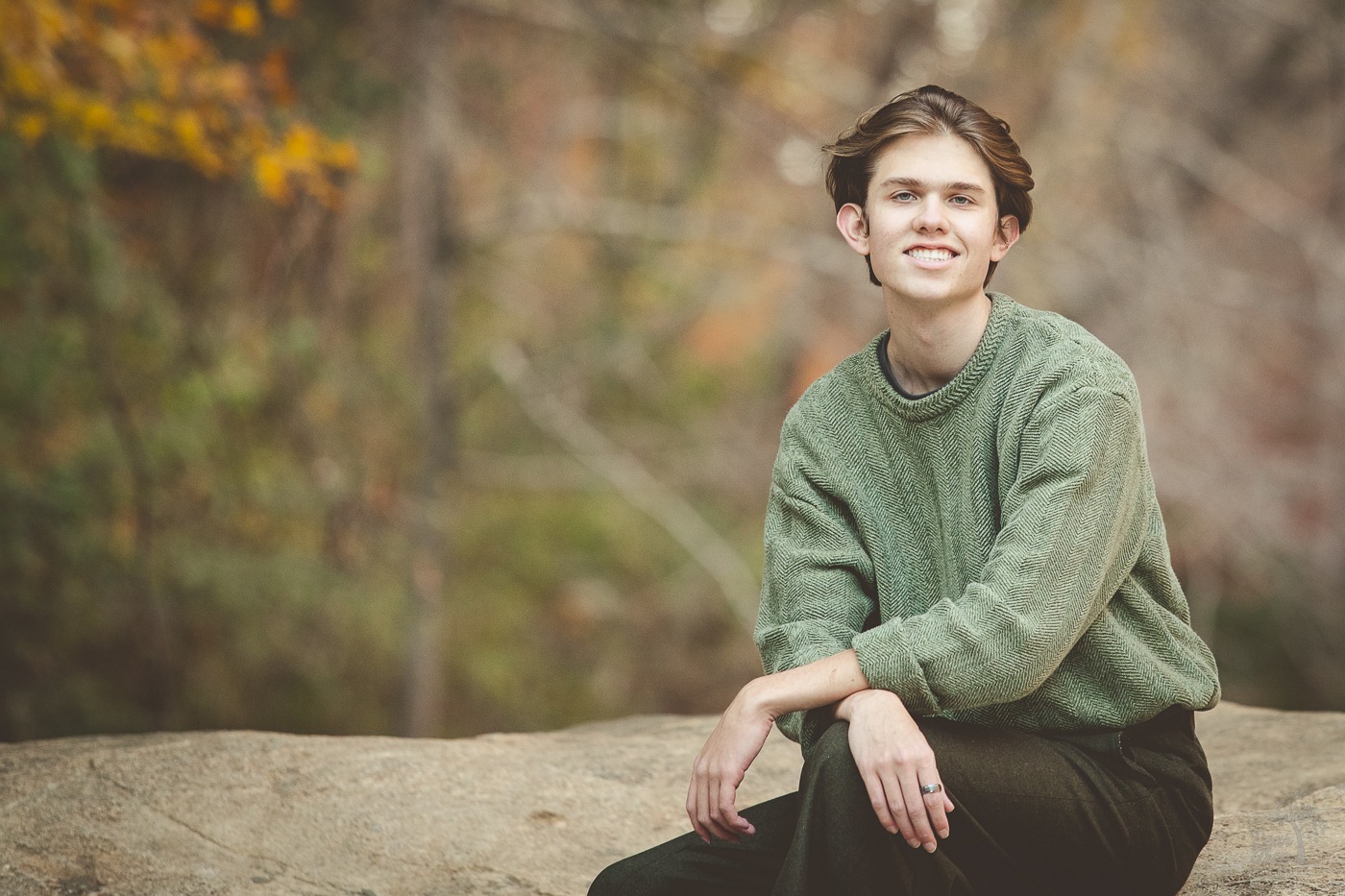 Canton high school senior boy sitting on a boulder at Sope Creek in East Cobb