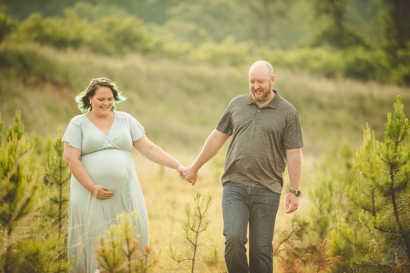 Pregnant couple holding hands while walking during their maternity session in Cartersville