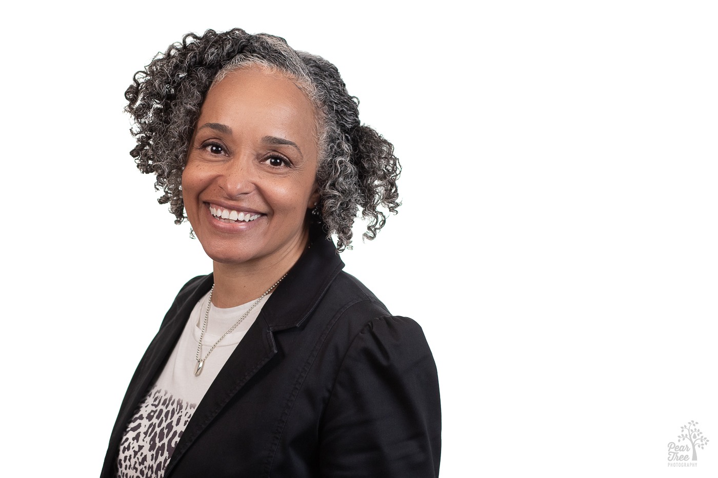 Dr. Aliezoria Redd wearing a black blazer over a blouse with a leopard print and a necklace while smiling pleasantly for her professional headshots in Atlanta