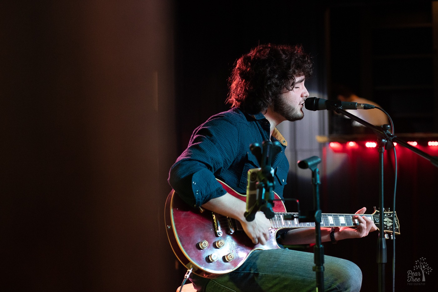 Hunter Rose singing on stage and playing his guitar