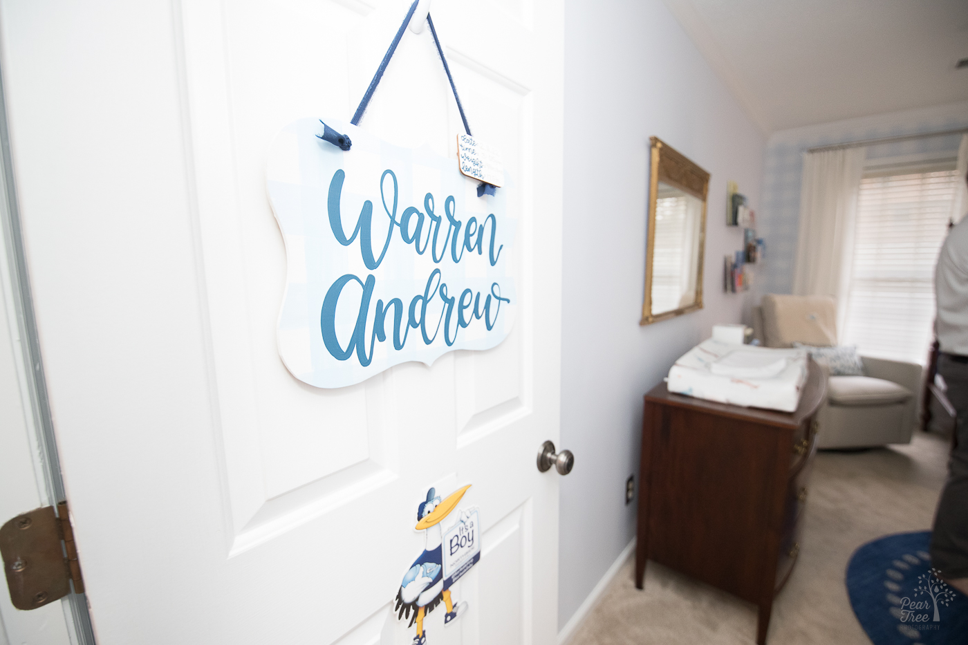 Open bedroom door with baby's name hanging on a handmade sign. Northside Hospital stork sign hanging below it.