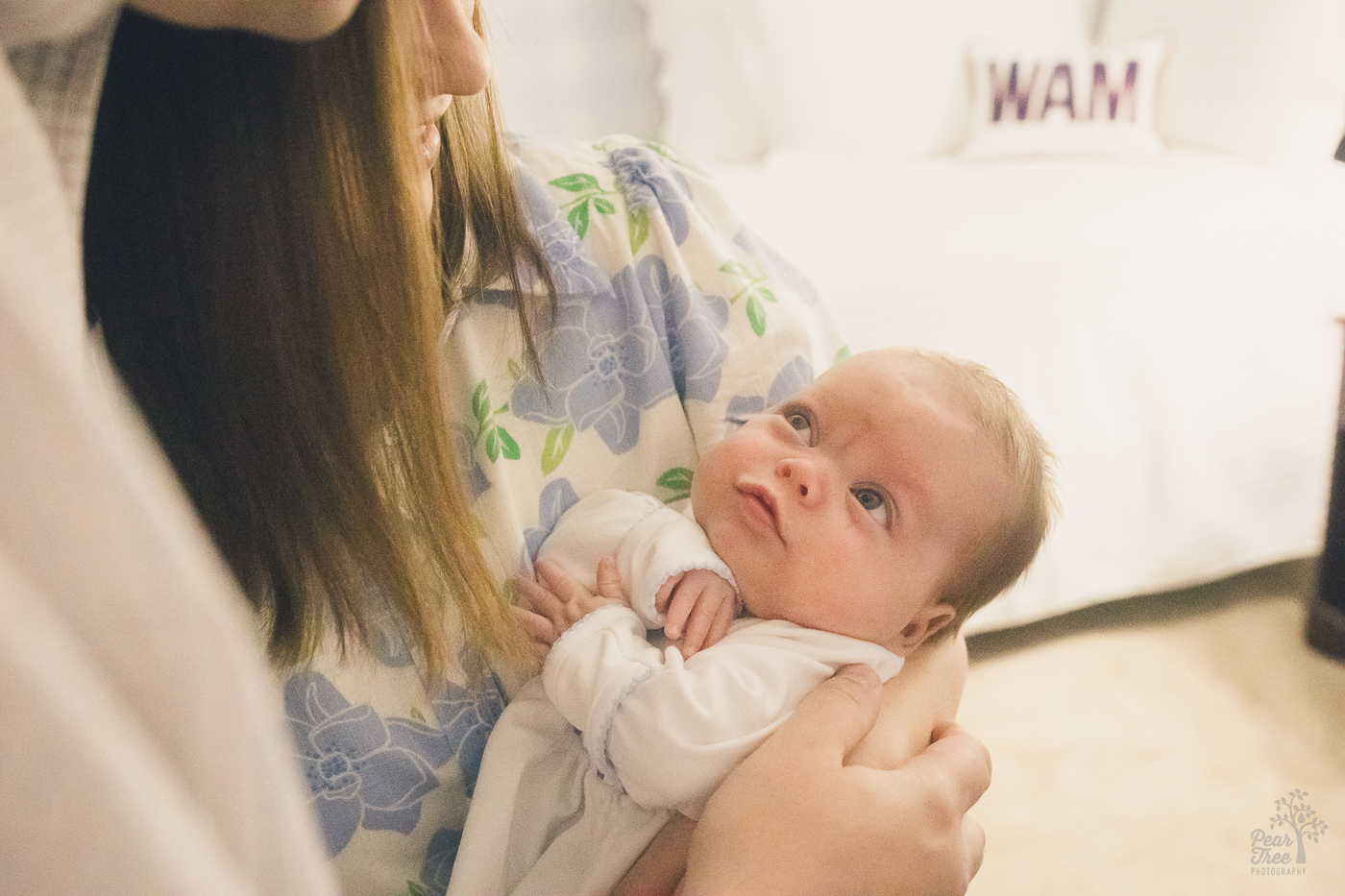 Baby boy being held close by his parents and starting to smile