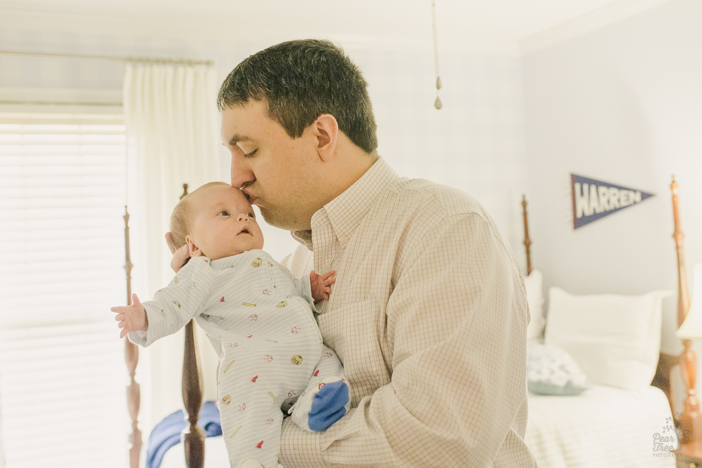 Dad kissing his baby boy's forehead