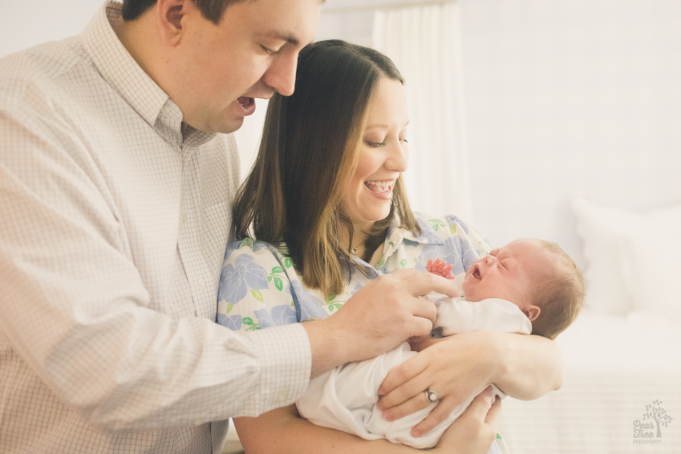 Happy parents holding their newborn baby boy and cooing over him