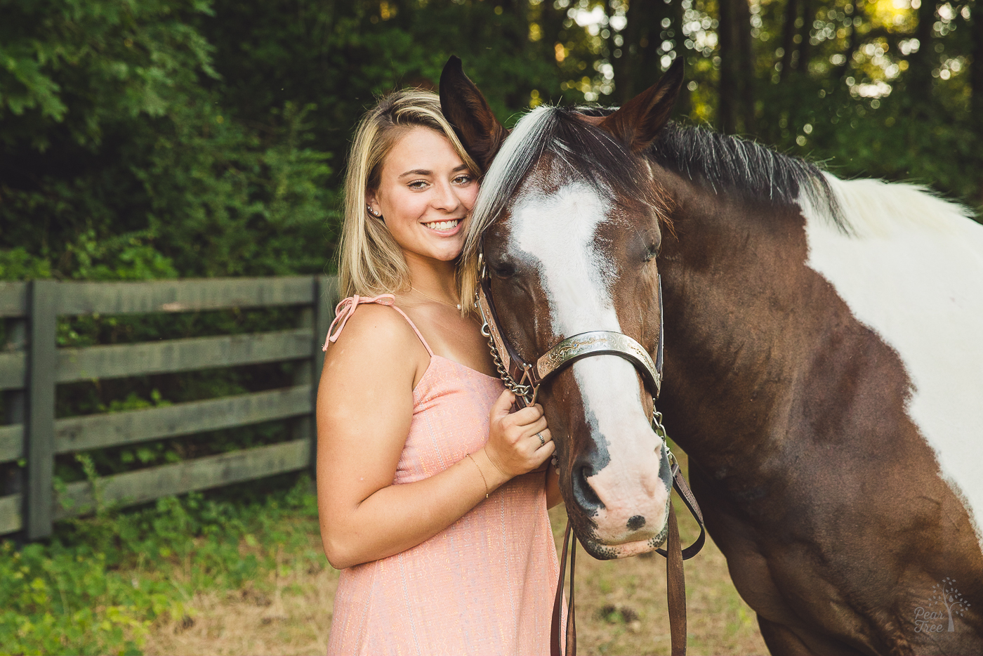 Senior photographs with a horse while the two stand close together