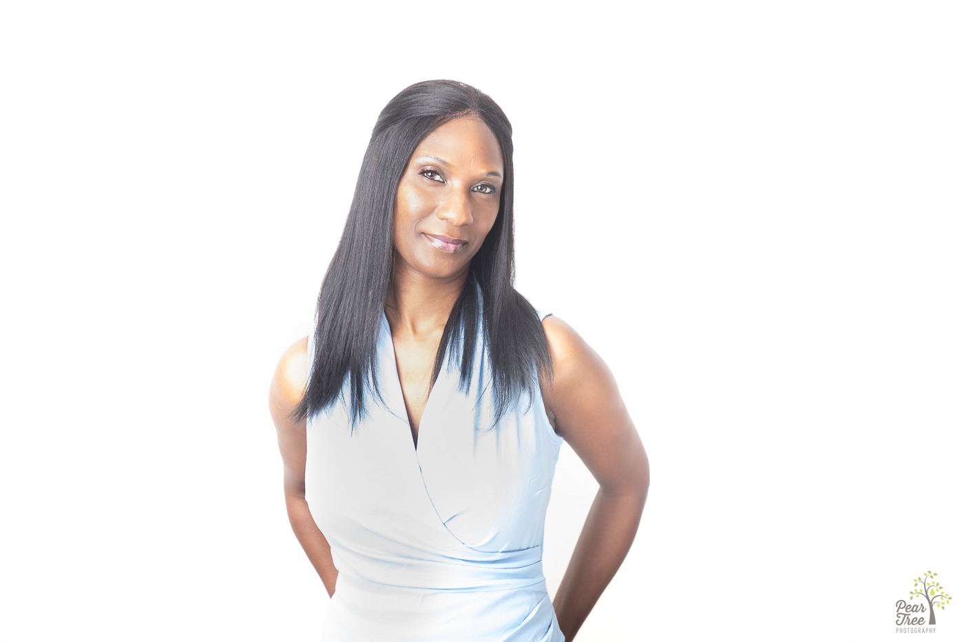 Attractive African American woman wearing a sleeveless V neck blouse and smiling for her Canton headshot session