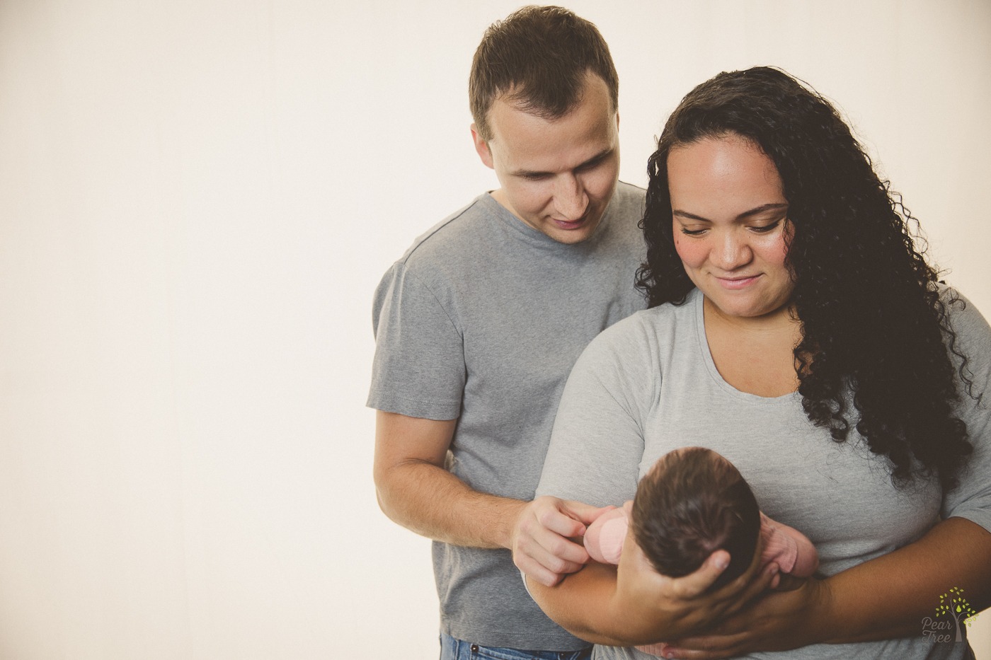 Parents holding newborn daughter close and smiling