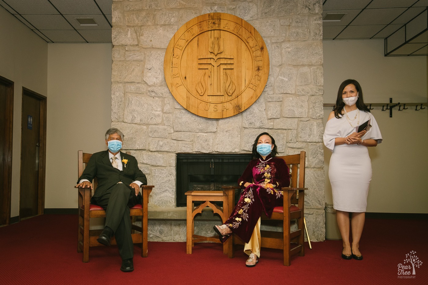 Vietnamese parents and aunt of the groom waiting in Eastminster Presbyterian Church lobby wearing masks and waiting