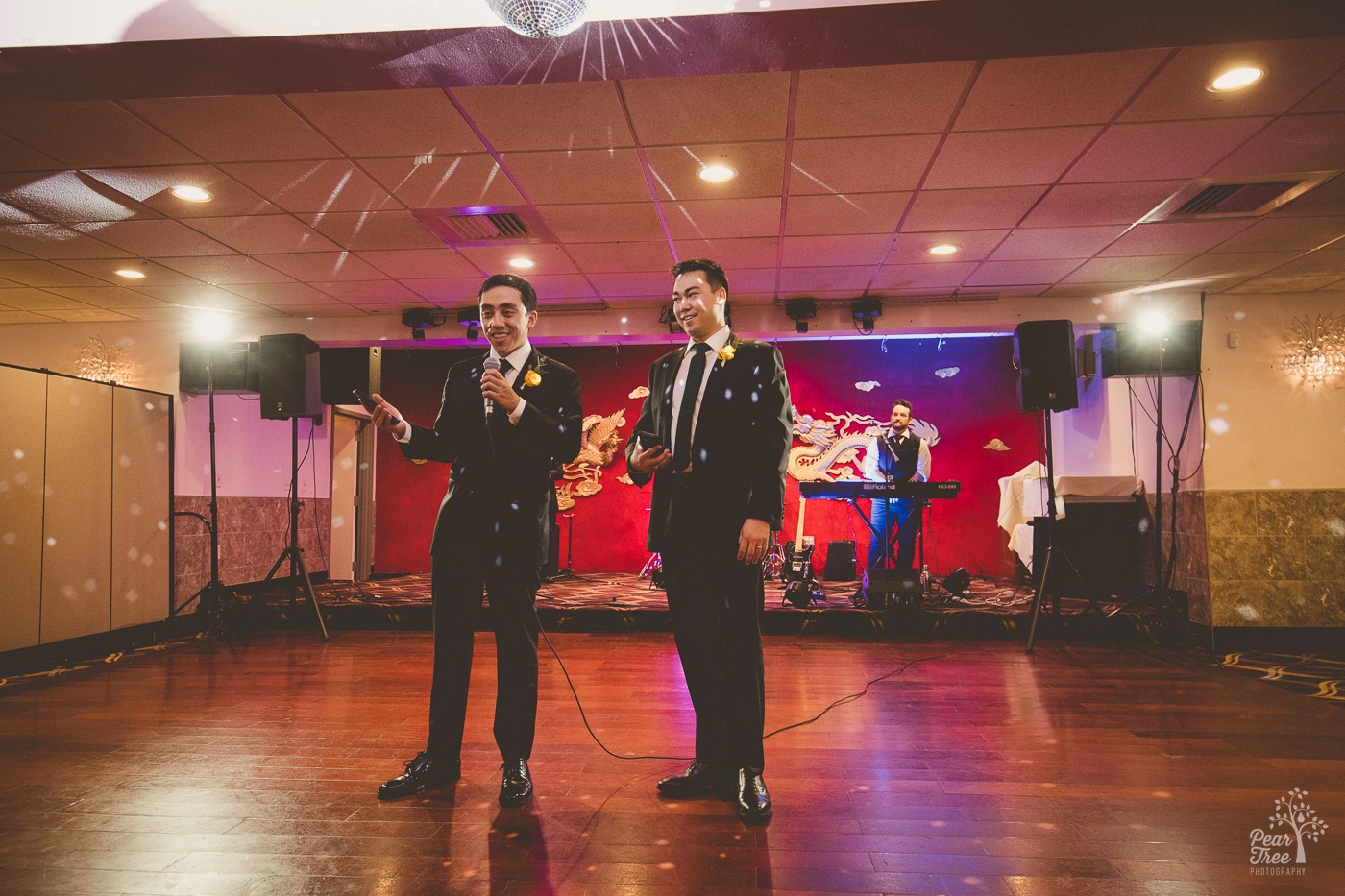 Asian brothers with a microphone on stage at Canton House wedding reception