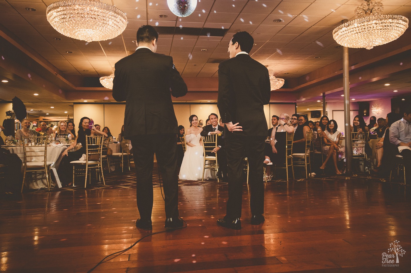 Asian bride's brothers backs are seen while they are toasting their sister and her Asian groom at Canton House wedding reception