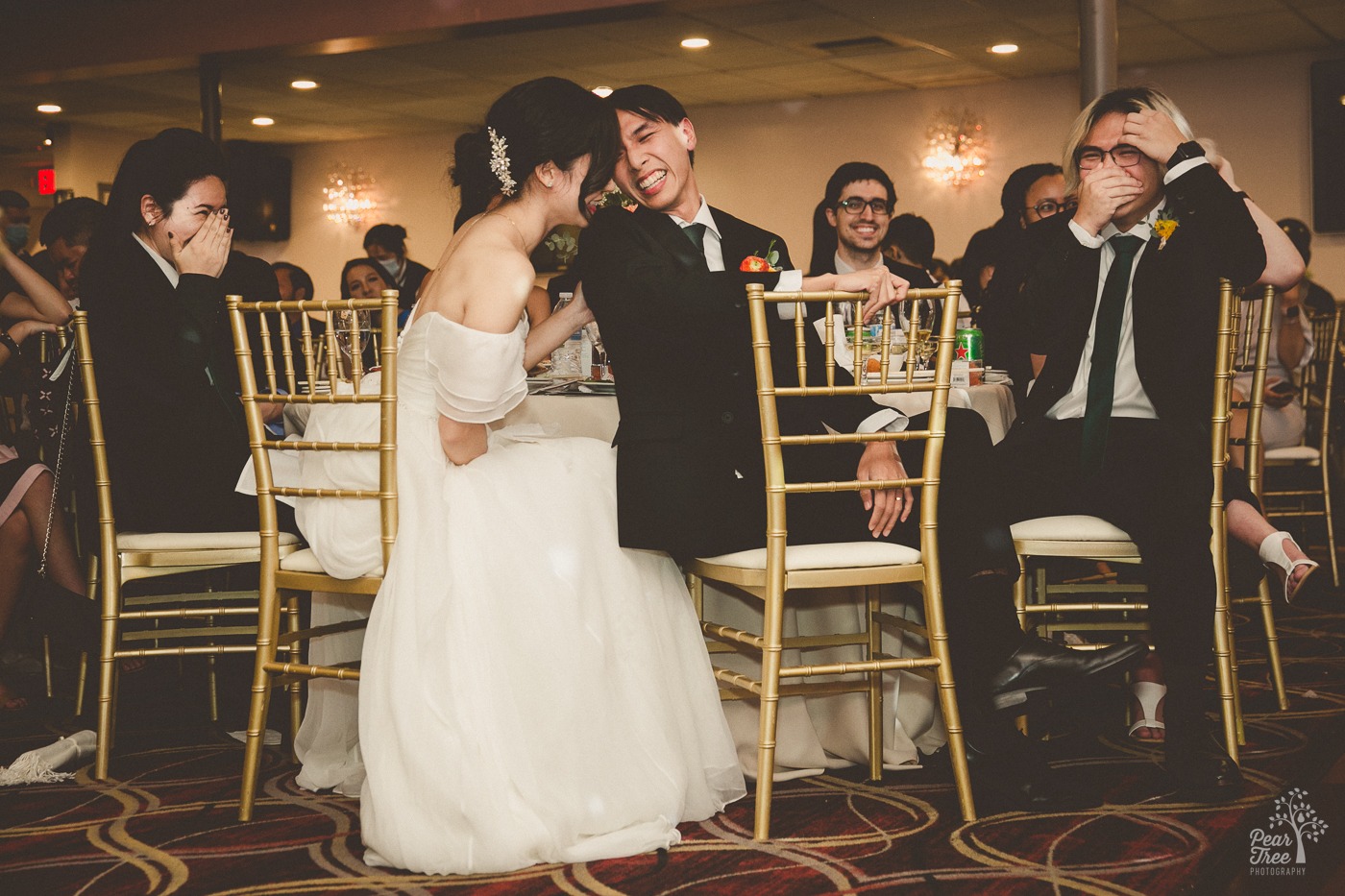 Asian wedding couple laughing and touching each other during wedding toasts