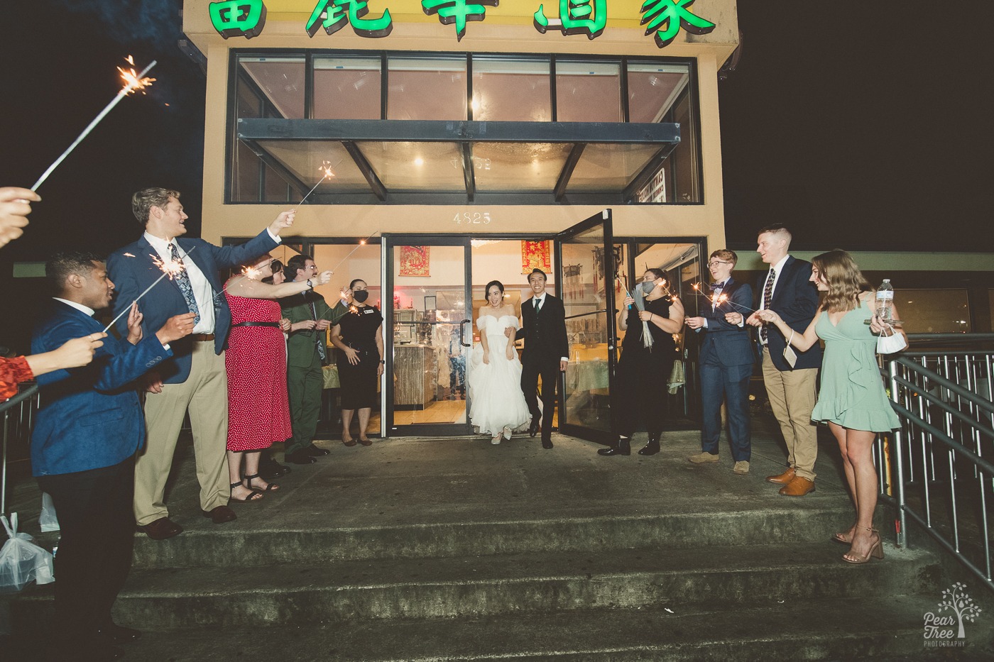 Asian newlyweds walking out of Canton house at night in Atlanta