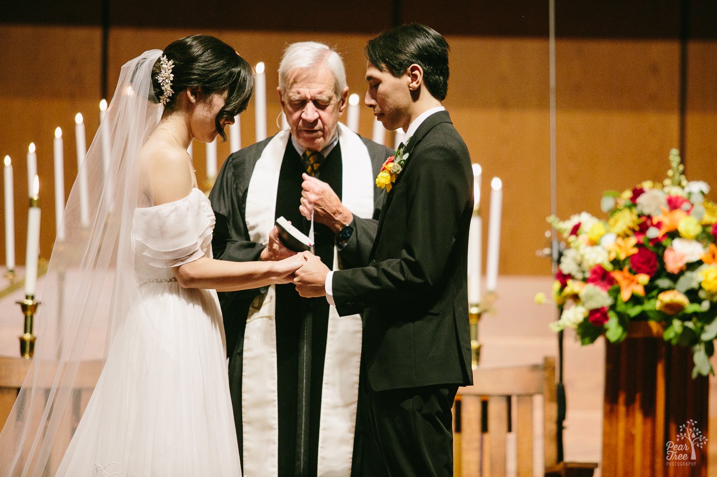 Officiant praying over Asian couple during Atlanta wedding ceremony