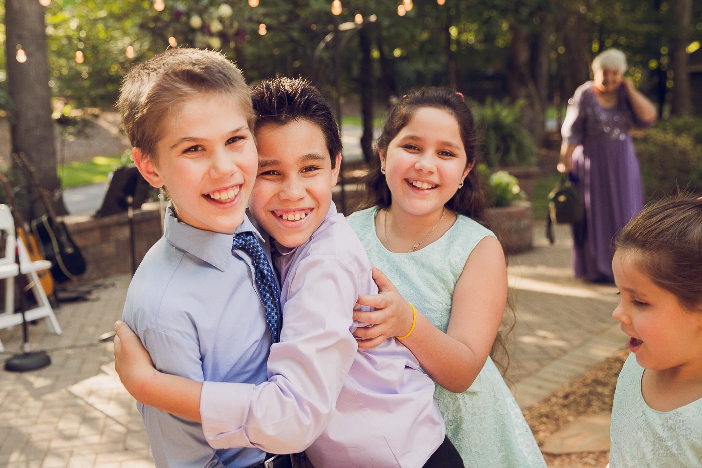 Children hugging and laughing on their parents' wedding day