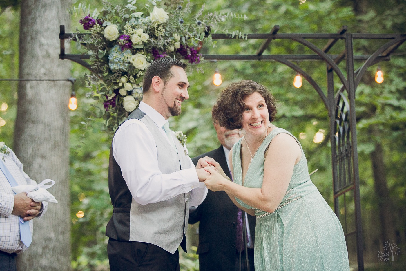 Bride and groom laughing and holding hands during ceremony