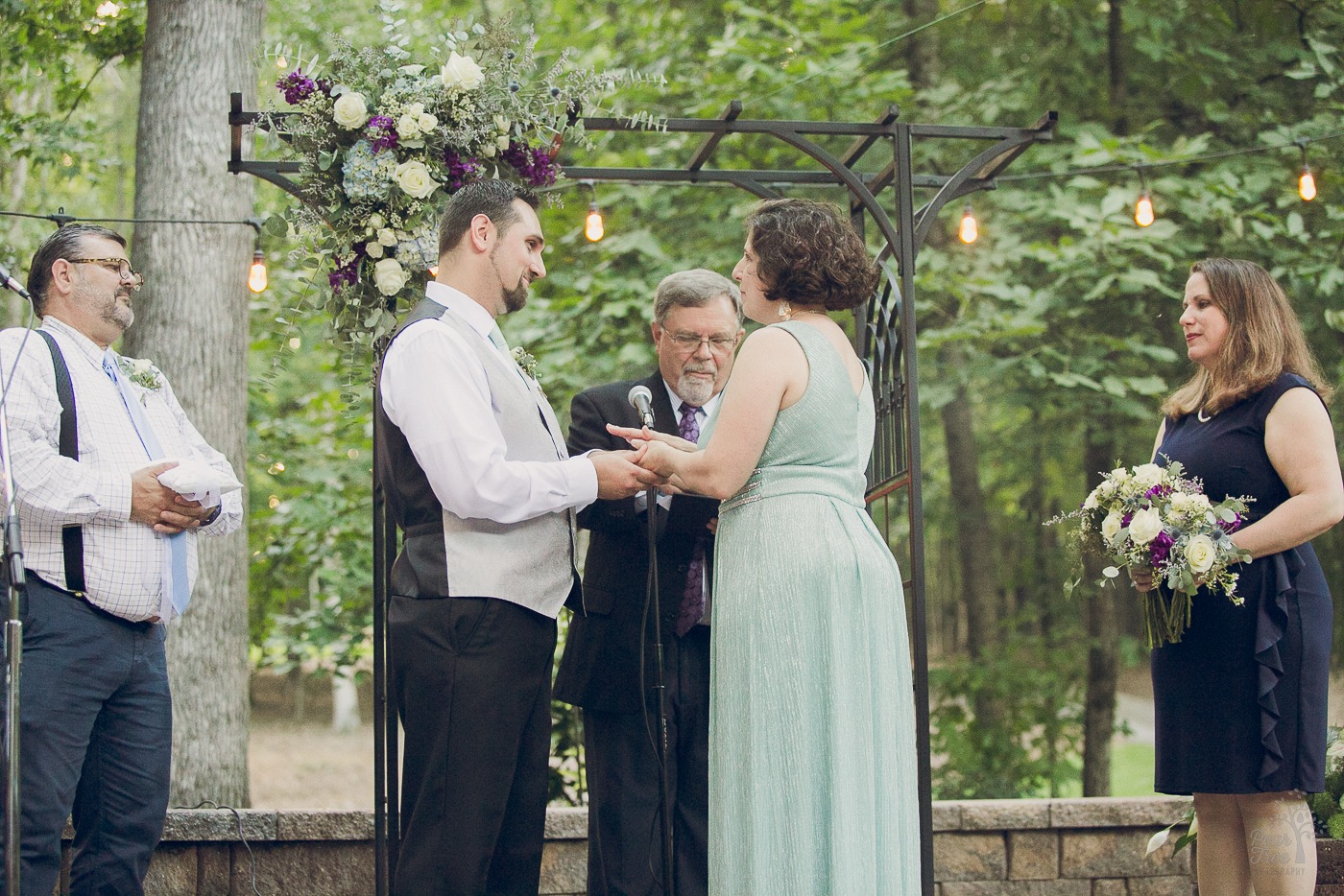 Bride and groom holding hands and looking at each other during wedding ceremony