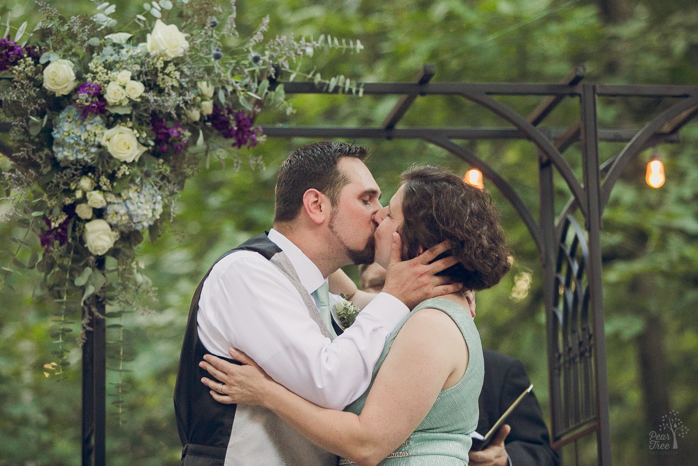 Groom kissing his bride in backyard wedding ceremony