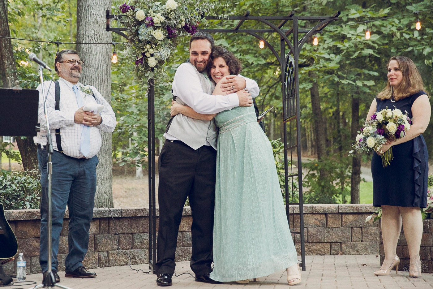 Bride and groom hugging in middle of wedding ceremony