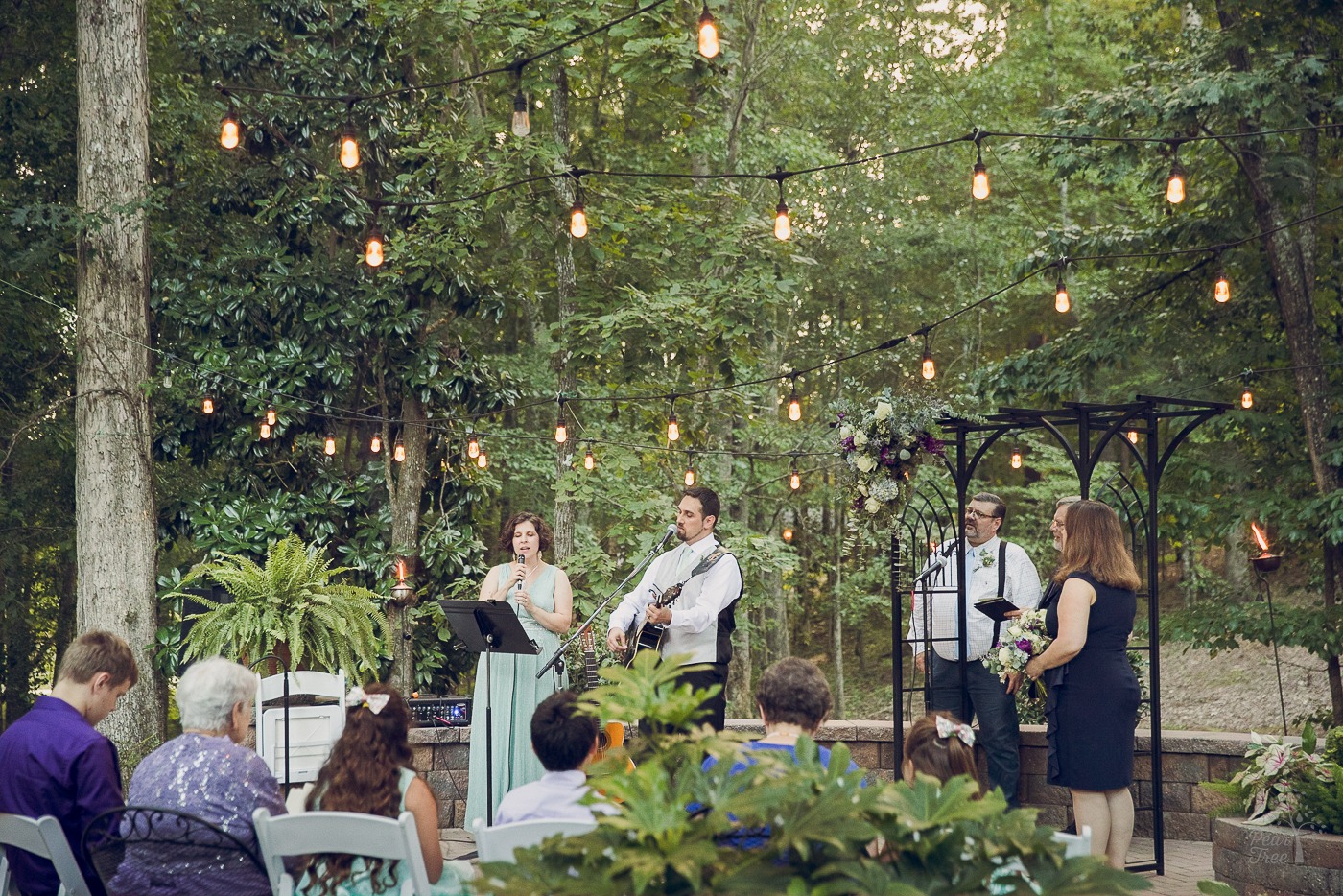 Backyard wedding ceremony with bride and groom singing
