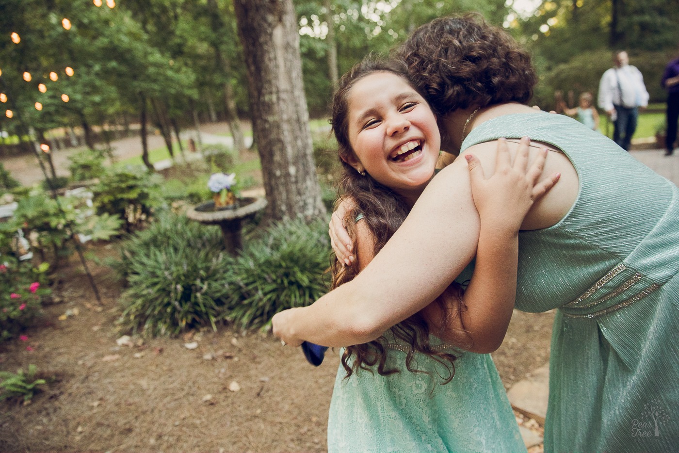 Daughter laughing while being hugged by her mom