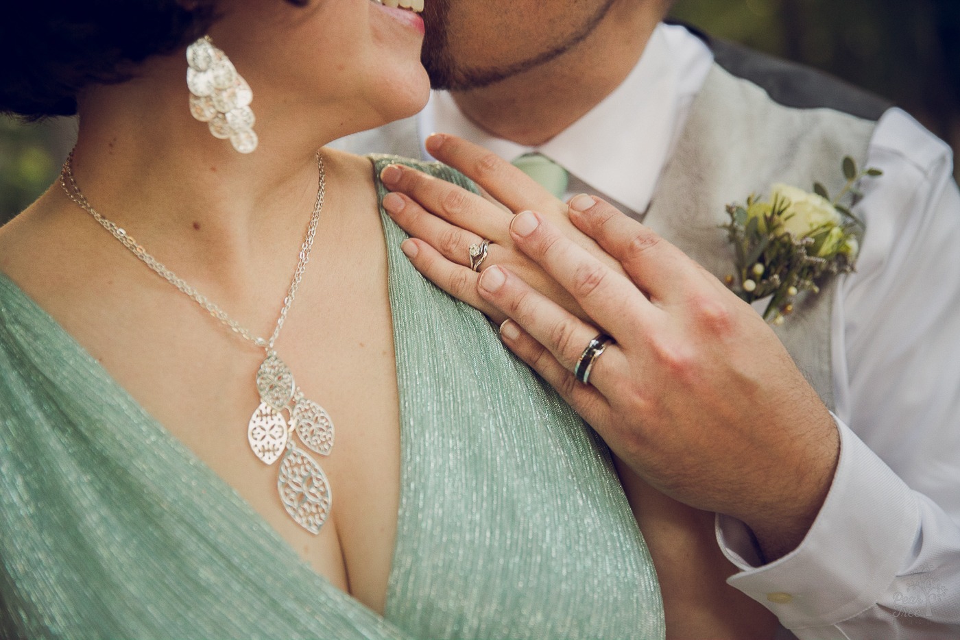 Ring shot of husband's hand holding his wife's on her shoulder