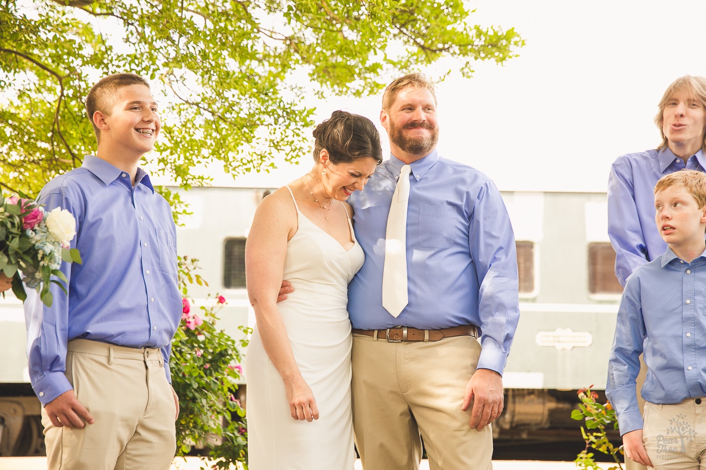 Bride, groom, and their sons laughing during their wedding ceremony at the Chattanooga Choo Choo hotel