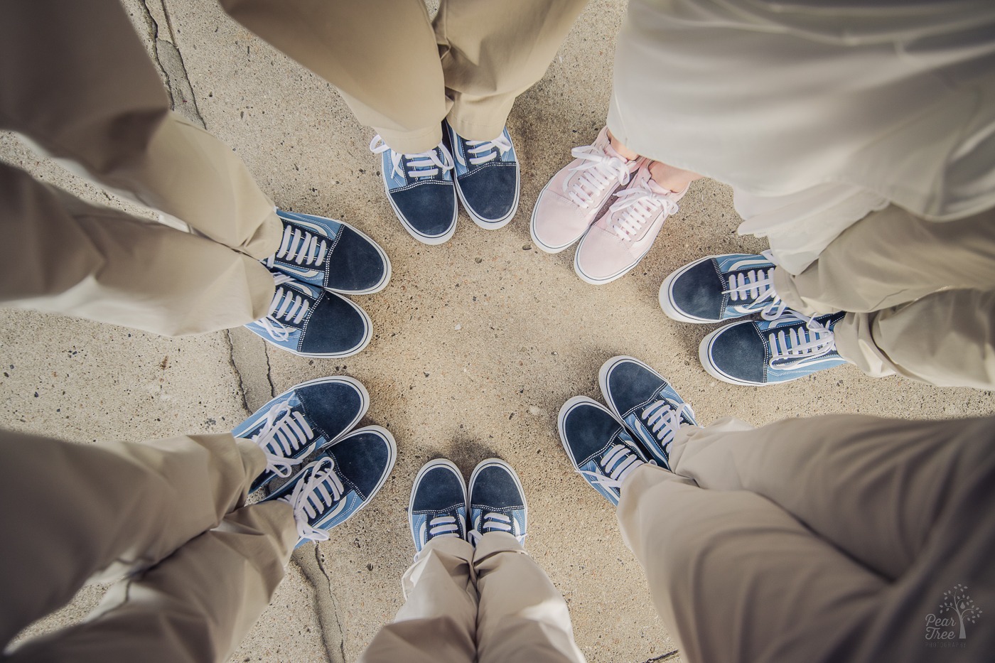 Six pairs of blue shoes and one pink for the bride as they stand in a circle