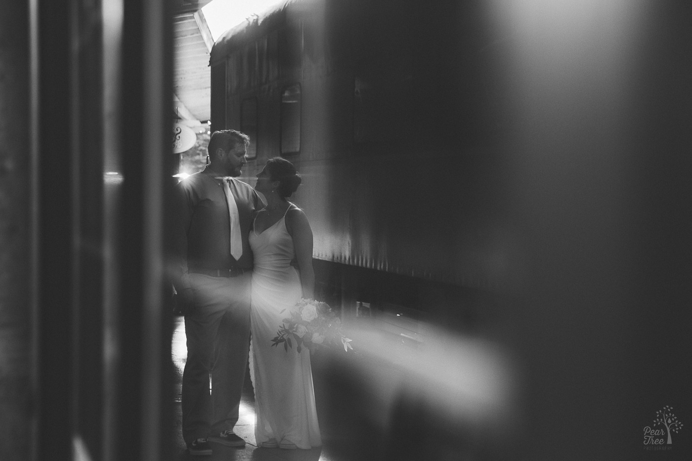 Black and white reflection of a bride and groom standing next to train cars at Chattanooga Choo Choo hotel