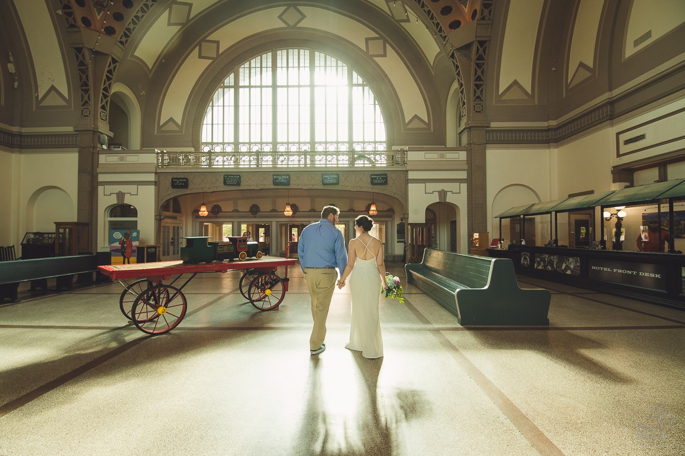 Bride + Groom holding hands while walking through Chattanooga Choo Choo hotel lobby