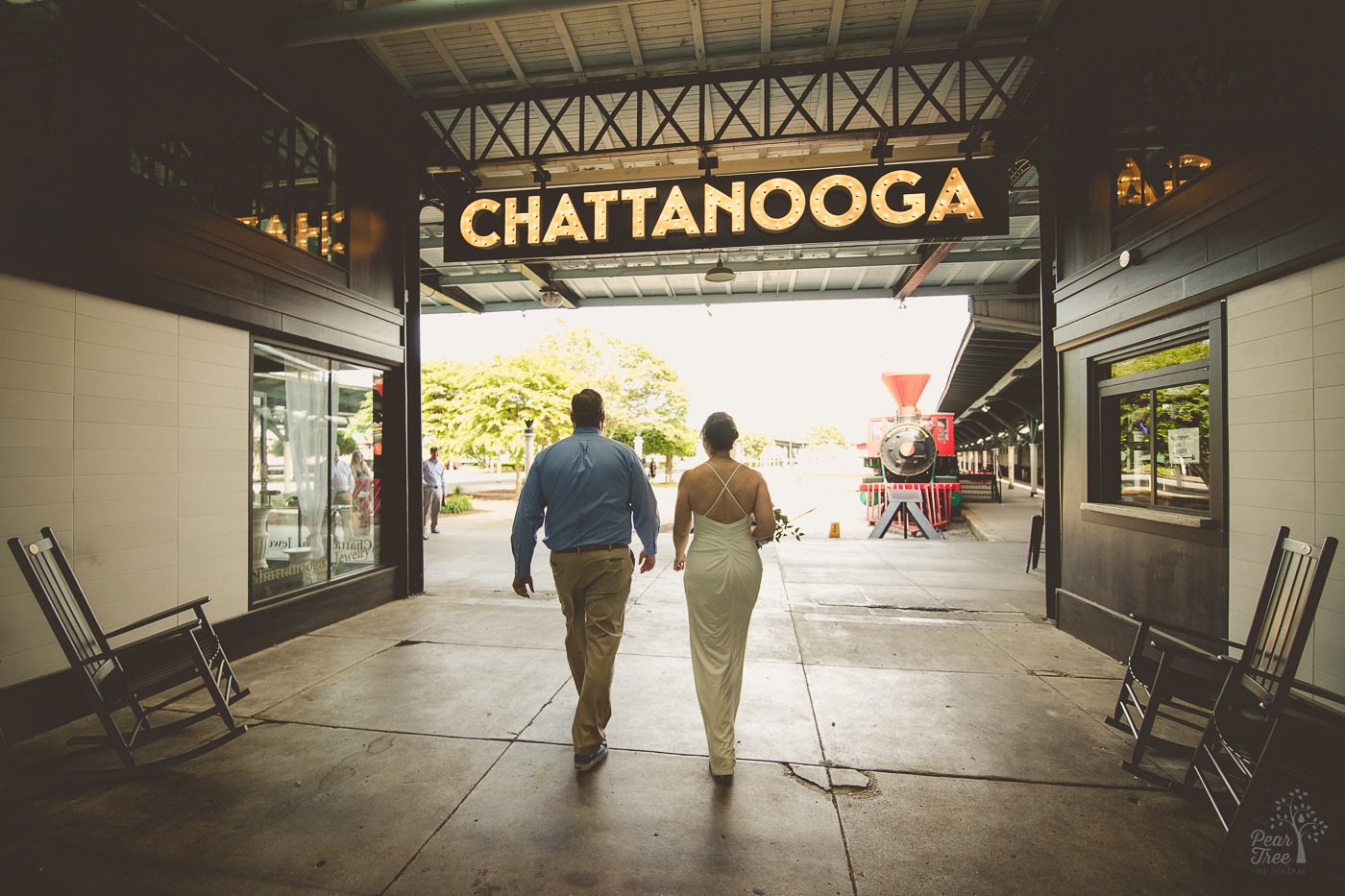 Bride and groom walking side by side under CHATTANOOGA sign at the Chattanooga Choo Choo hotel before their wedding ceremony