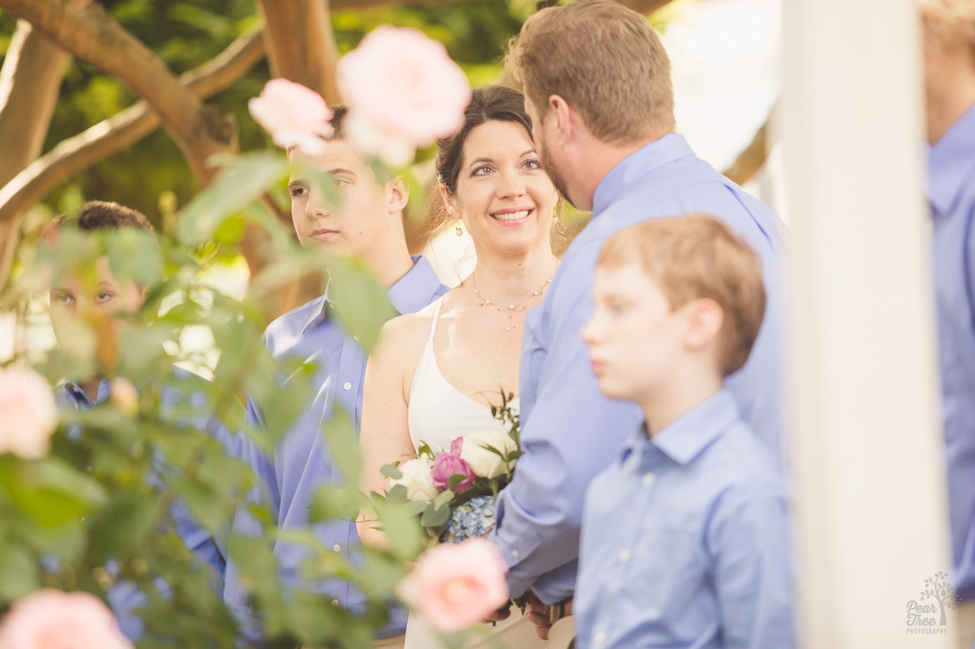 Bride smiling up at her groom with flowers surrounding them