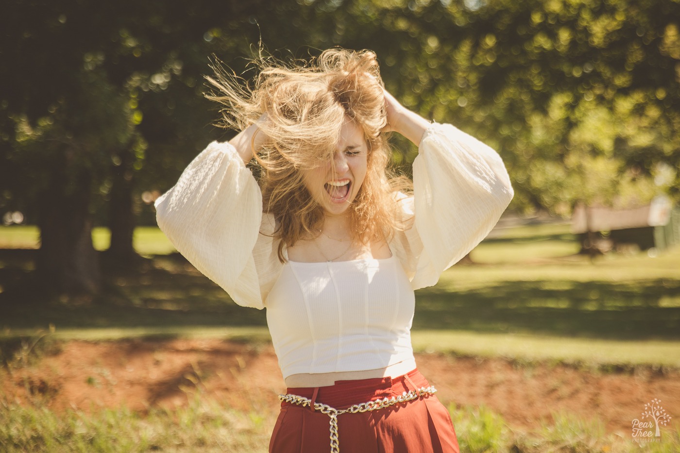 Teenage girl yelling as she messes up her hair with her hands