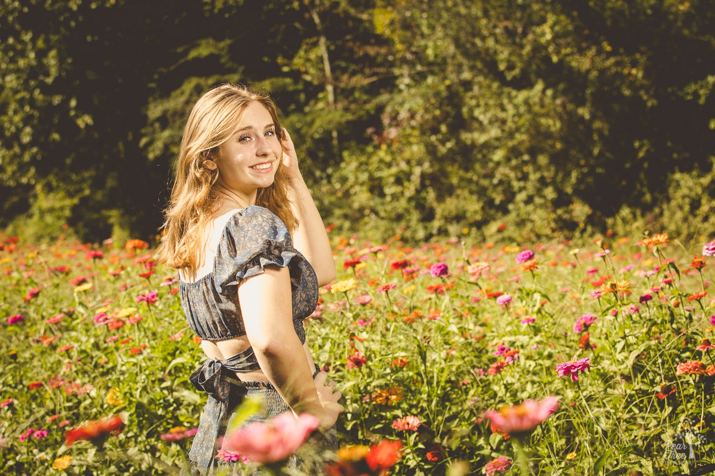 Teenage girl looking over her shoulder and smiling in a wildflower field